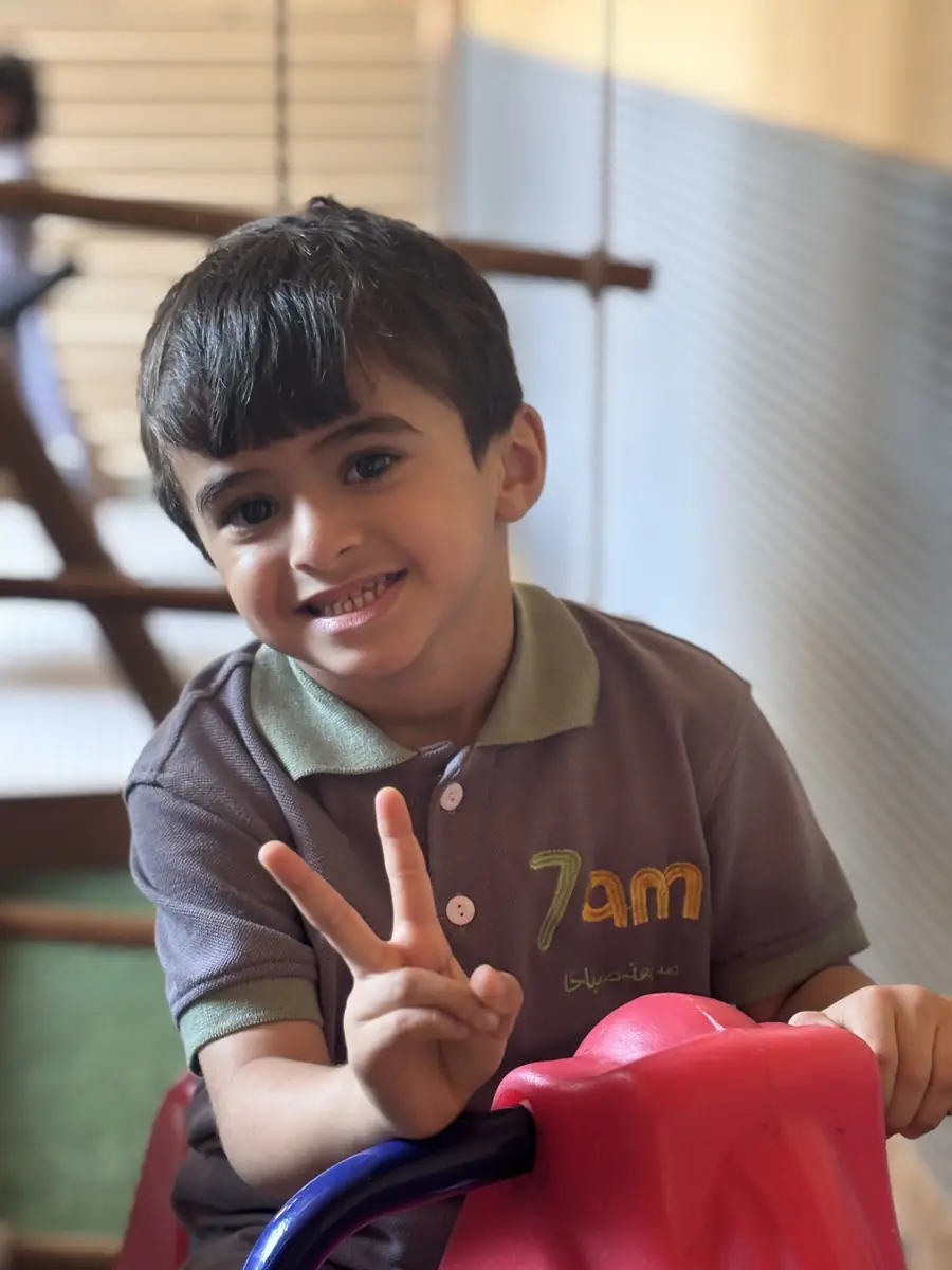 طفل مبتسم يلوّح بعلامة النصر في 7AM KIDS